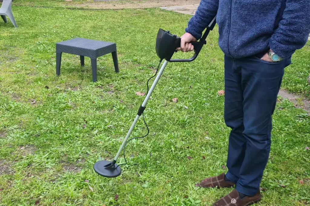 men holding a metal detector device